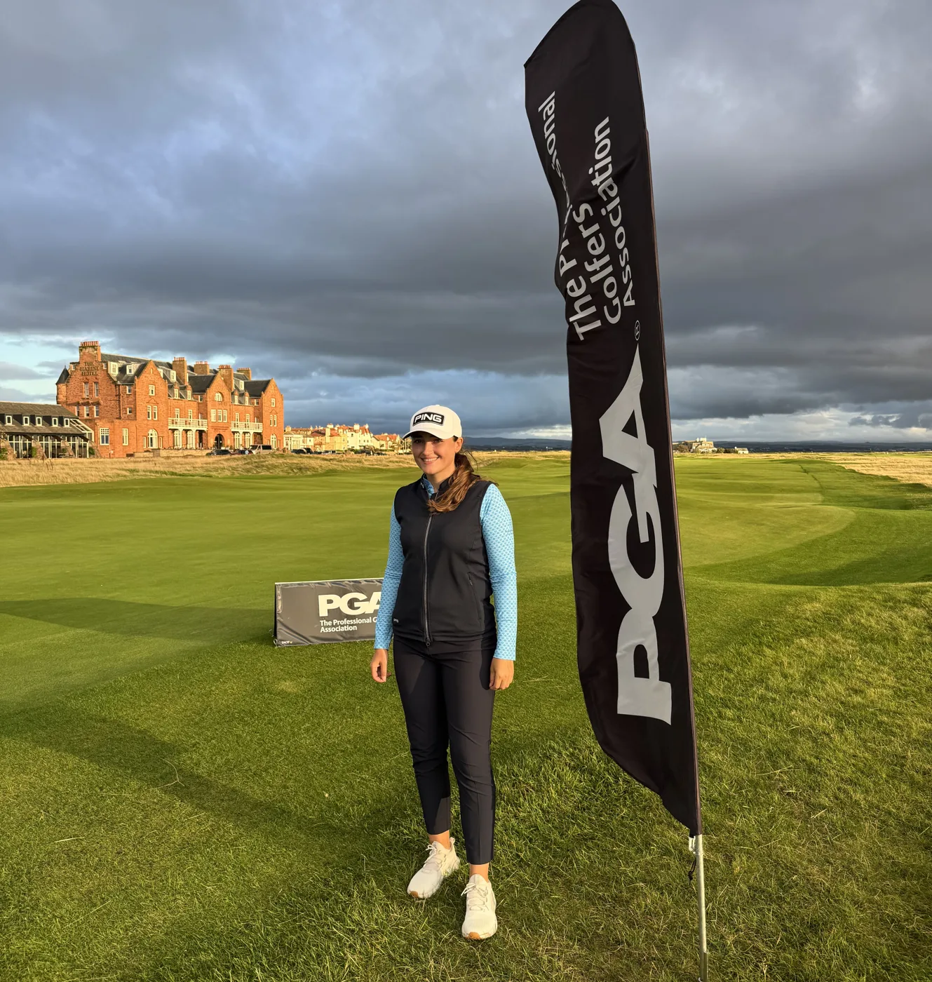 Jae Bowers beside a PGA flag at Royal Troon